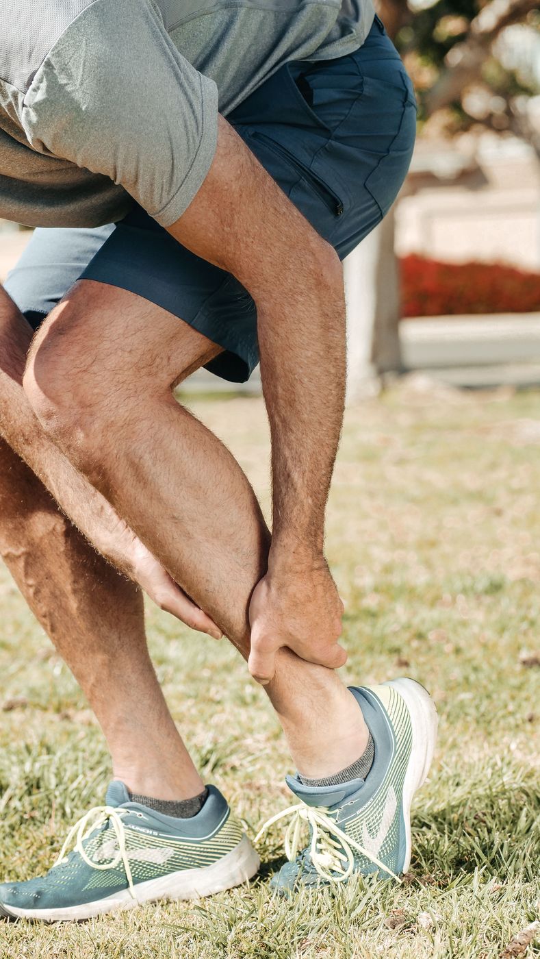 Runner holding his lower calf above the Achilles tendon