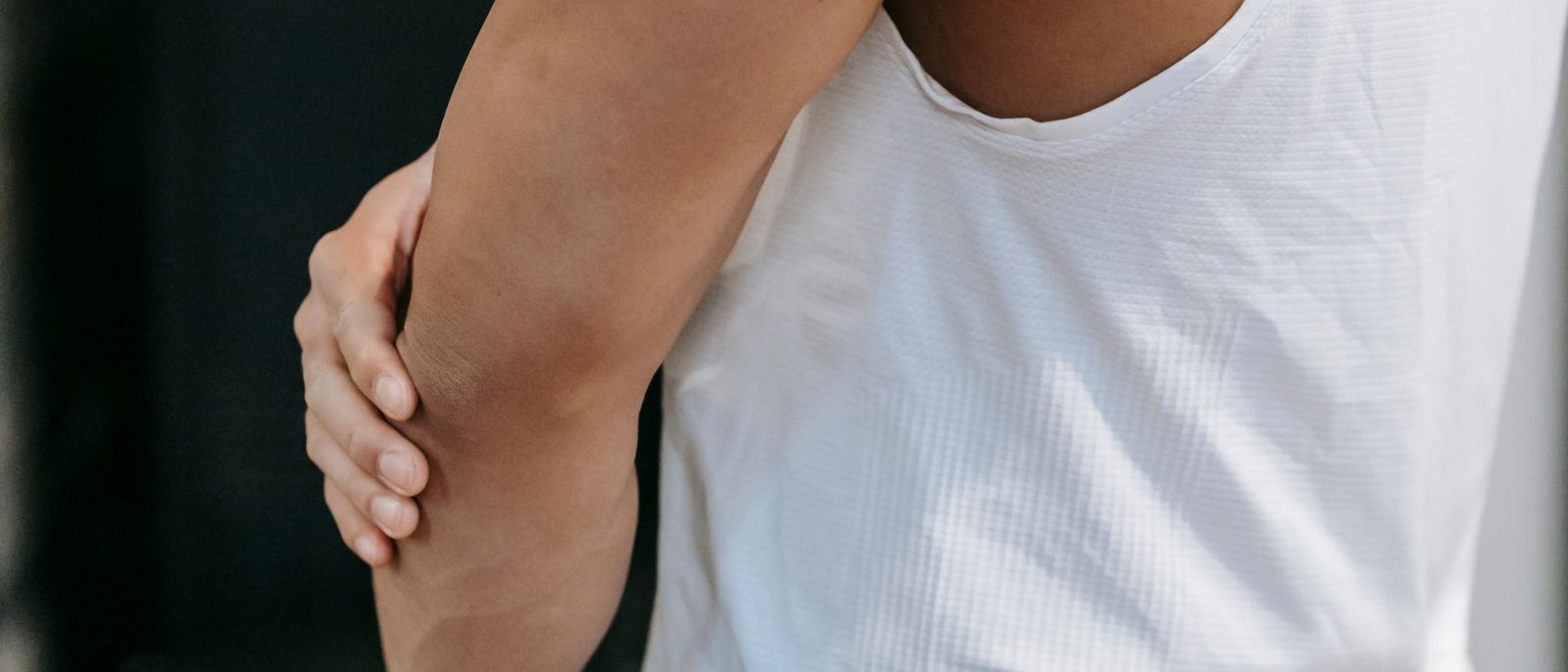 Man gripping the inside of his forearm just below the elbow