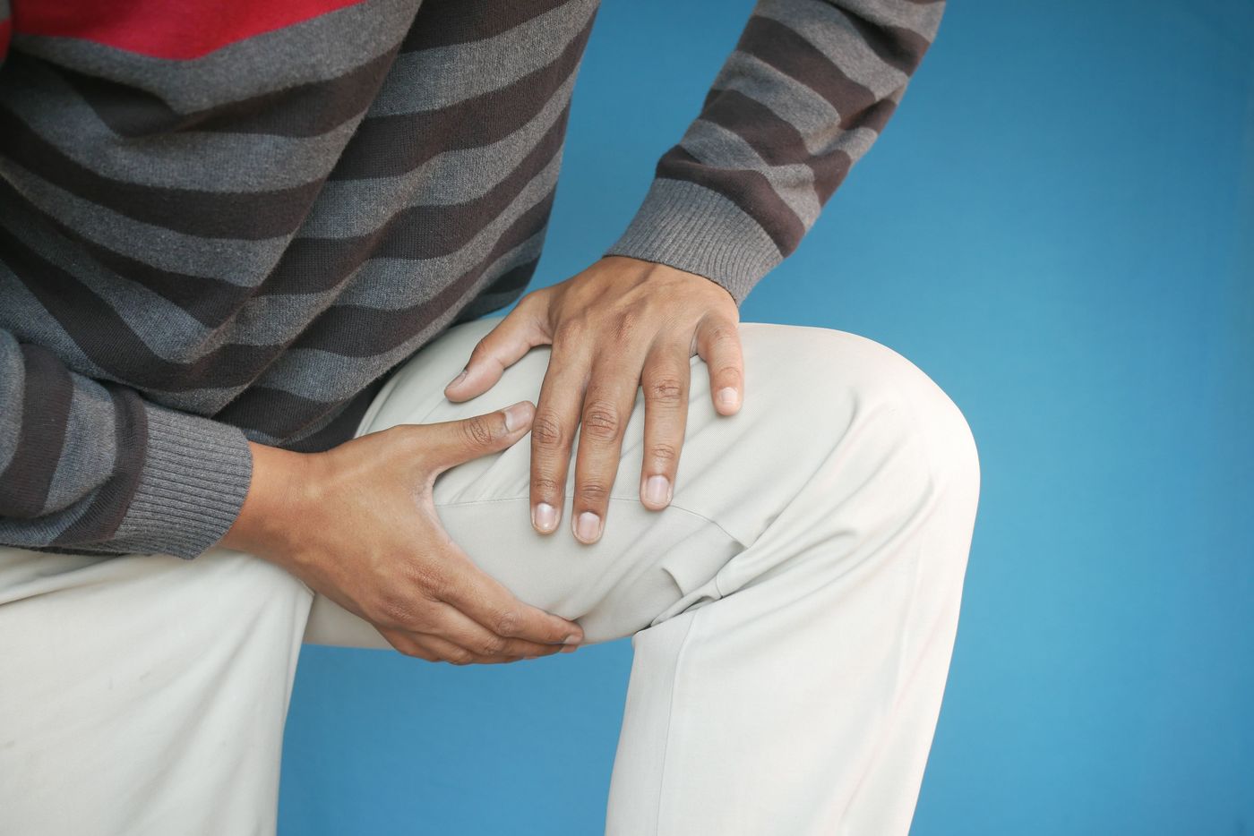 Hands holding the front of the hip and thigh