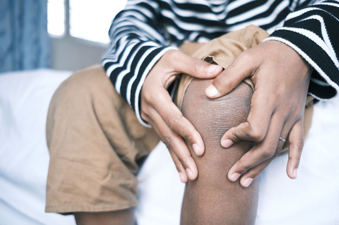 Hands holding a painful knee