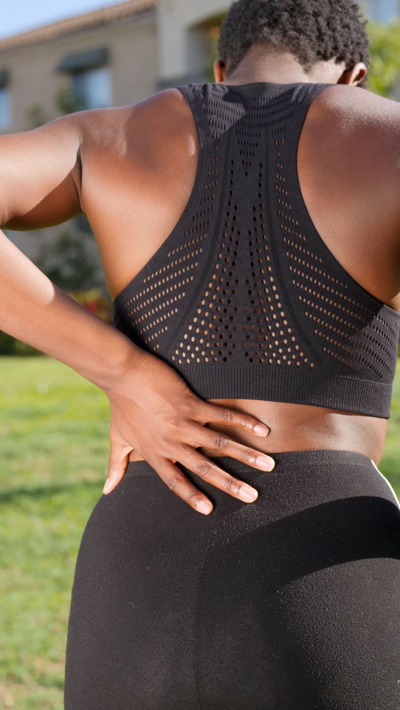 Person holding their lower back