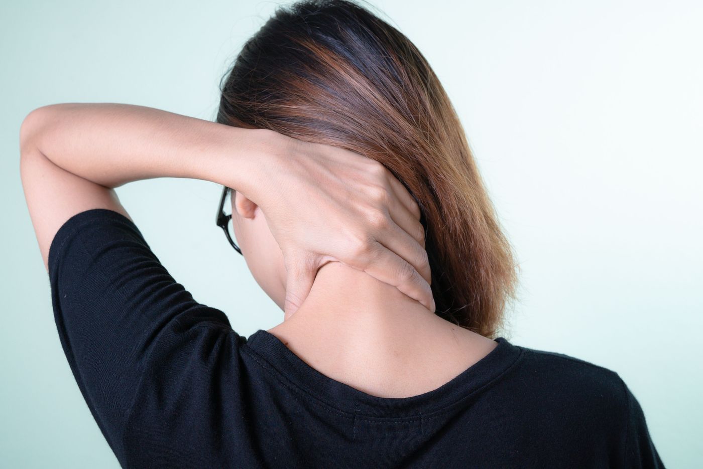 Person holding the back of their neck