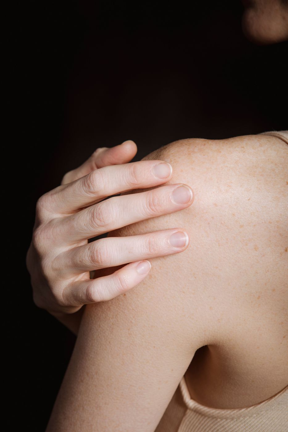 Hand resting on a painful shoulder