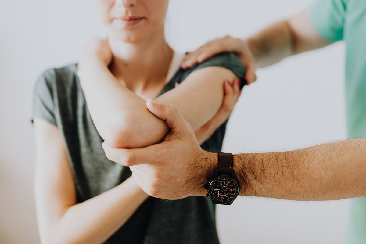 A physiotherapist assessing a client’s elbow
