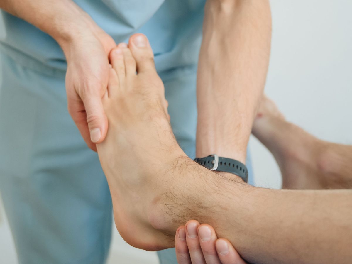 A physiotherapist moving a client’s foot and ankle