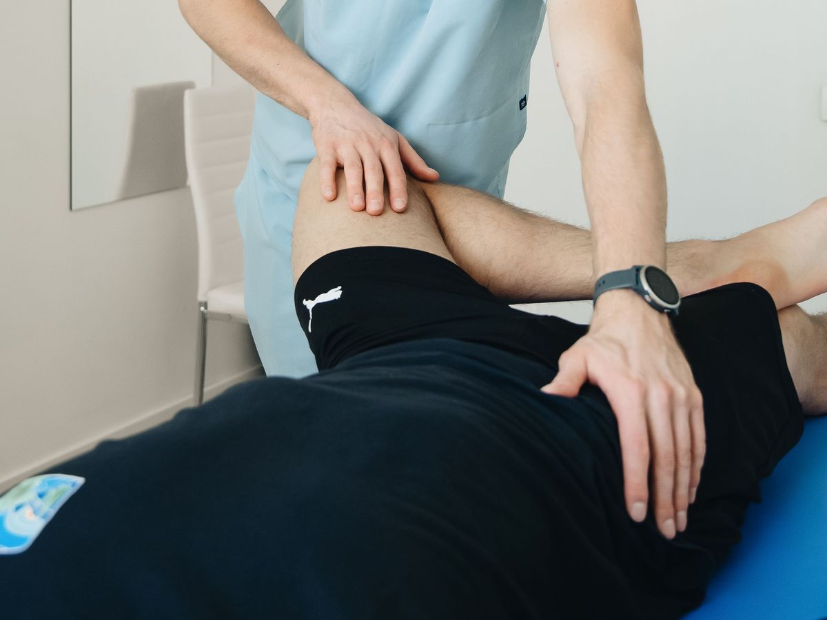 A physiotherapist assessing the hip with the client lying on their side