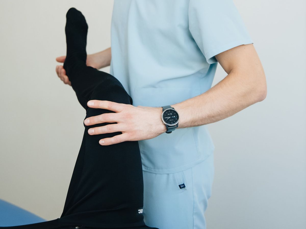 A physiotherapist bending a client’s hip and knee