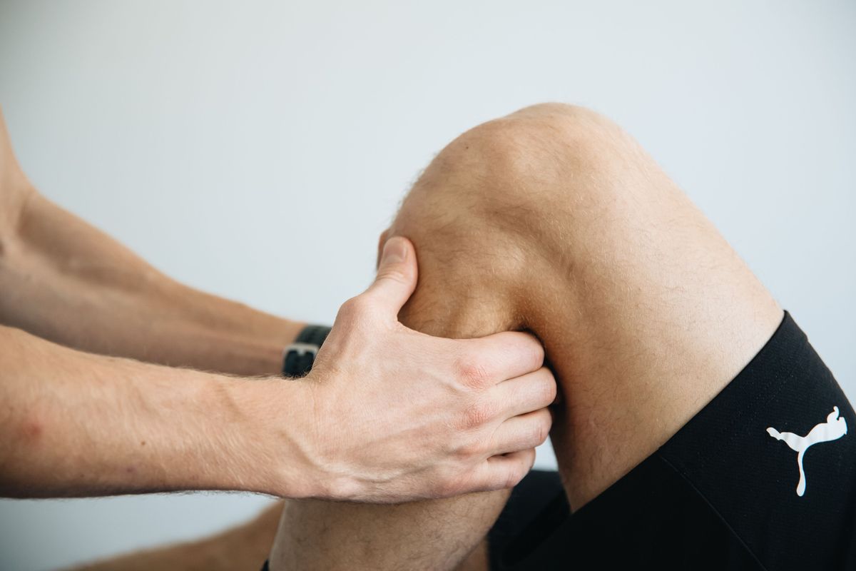 A physiotherapist examining the front of a client’s knee