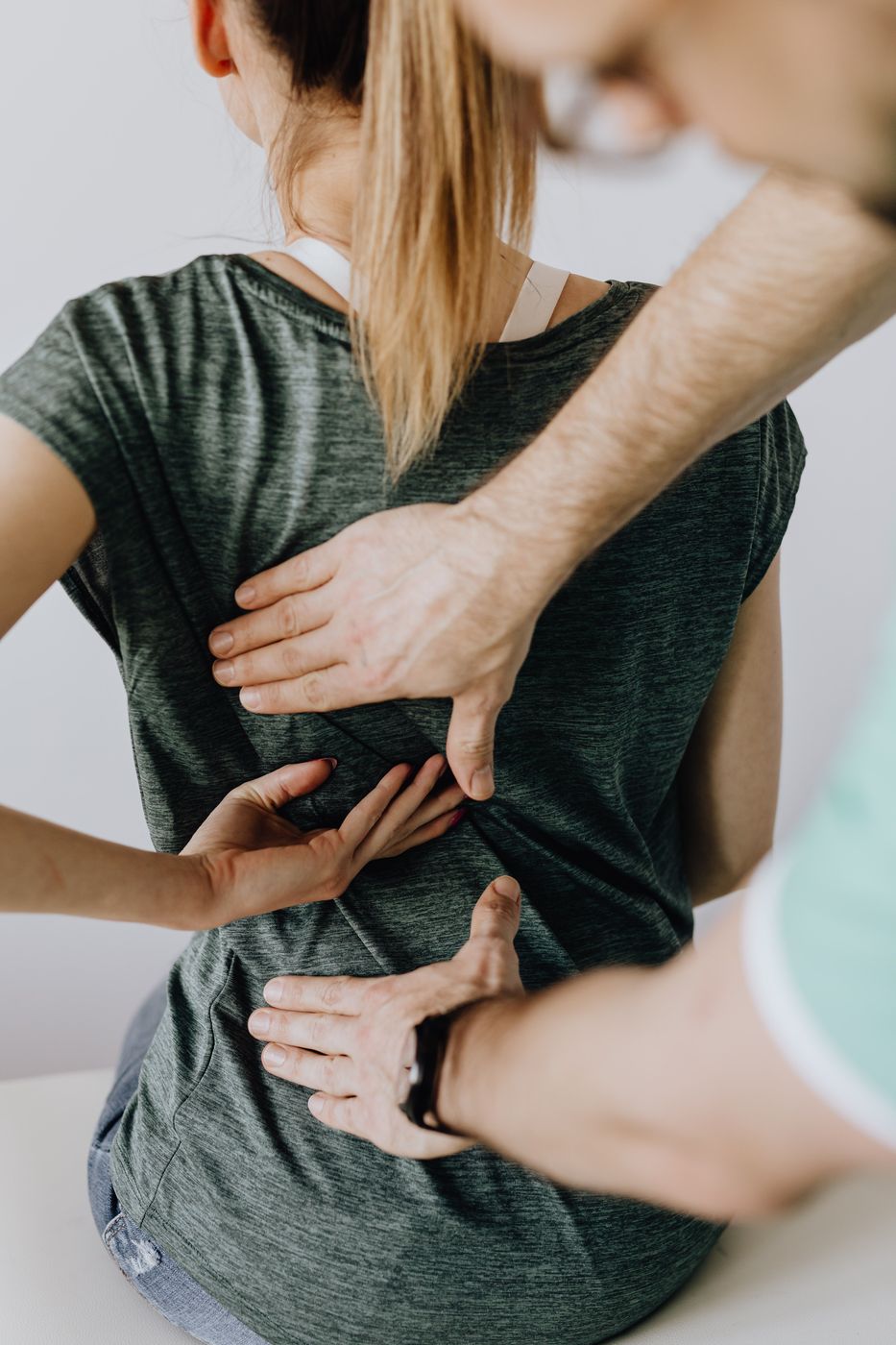 A physiotherapist checking how a client’s back moves