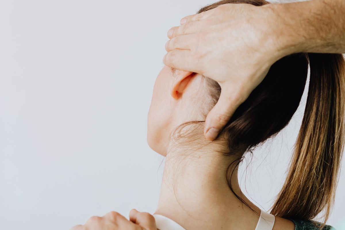 A physiotherapist guiding a client’s neck movement